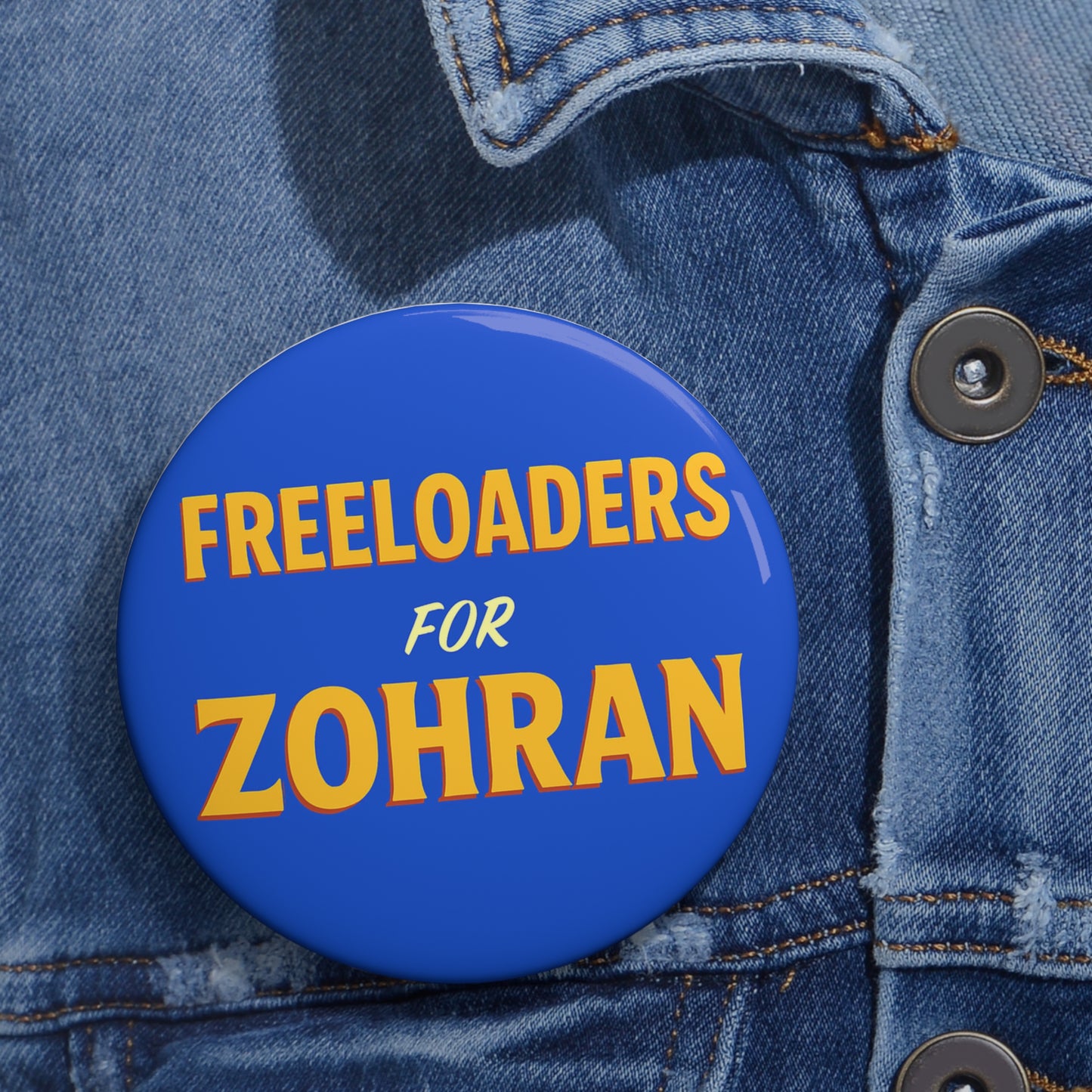 Blue button with 'Freeloaders for Zohran' text on a denim jacket