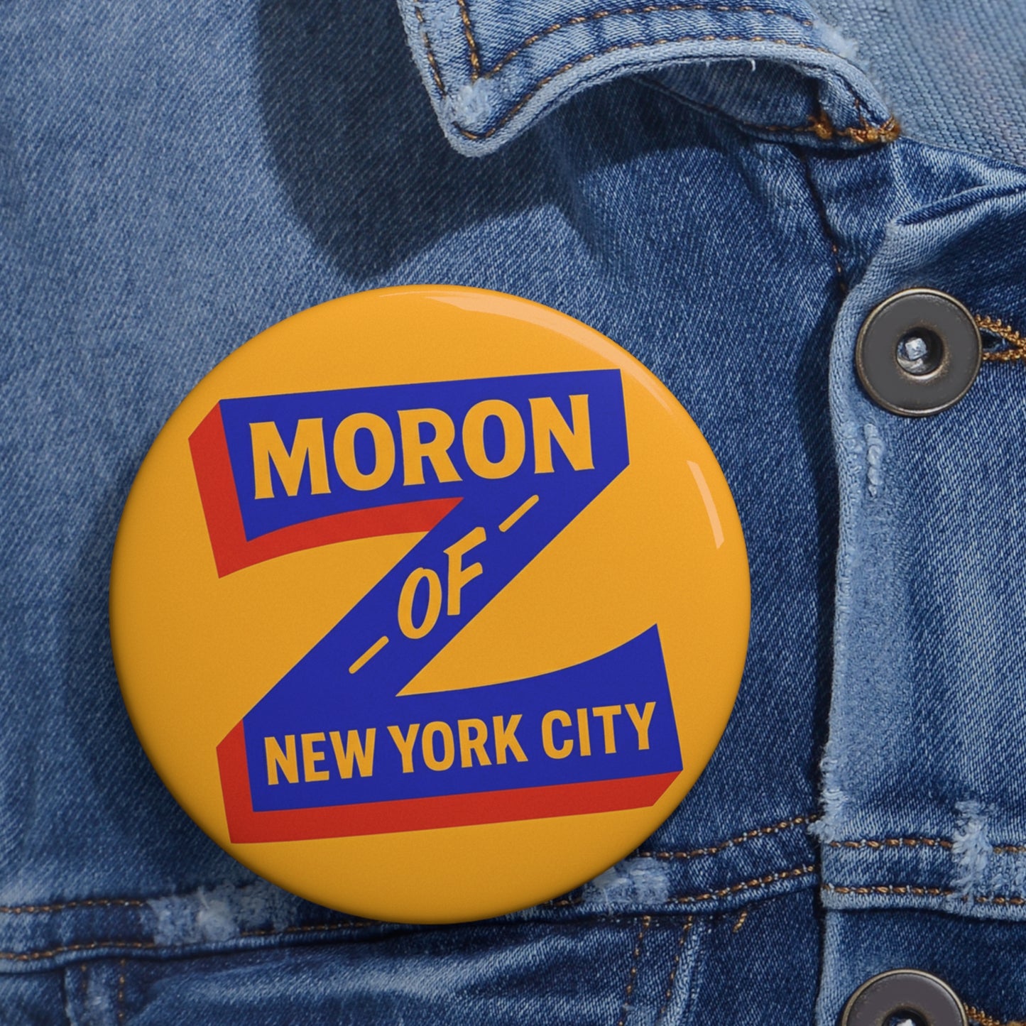 Button with 'Moron of New York City' text on a denim jacket